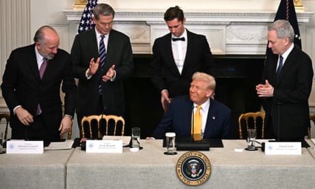 Man sits down while people applaud